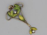 une image représentant une broche ornée de feuilles et d'une perle