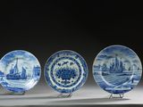 trois assiettes bleues et blanches ornées de bateaux, posées sur une table