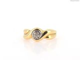 a close up of a gold ring with a diamond in the center