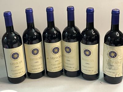 six bouteilles de vin rouge sont alignées sur une table
