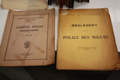 Deux vieux livres sont posés sur une table, à côté d'une pile de livres