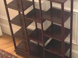 une bibliothèque dans un coin d'une pièce où se trouve un tapis au sol