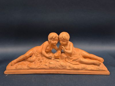 deux figurines représentant deux enfants allongés sur le sable