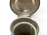 a silver cup sitting on top of a silver plate