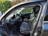 a car with the door open sitting in the grass