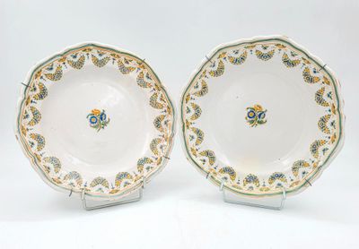 paire d'assiettes ornées de motifs dorés et verts sur fond blanc