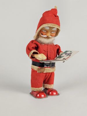 a figurine of a santa claus reading a book