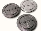 three black and silver metal buttons with the word chanel on them