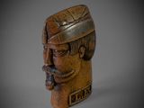 a close up of a wooden statue of a man wearing a hat