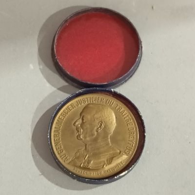 a close up of a coin with a red tin in it