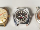 three different types of watches are displayed on a white surface