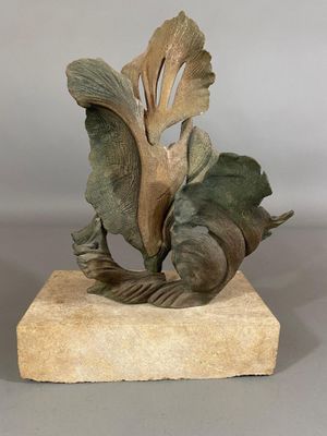 sculpture of a fish and a leaf on a stone base