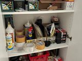a white cupboard filled with various items in a room