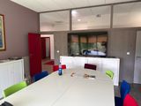 brightly colored chairs around a white table in a room with a flat screen tv