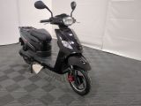 the motor scooter is parked in the garage on the floor