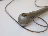 a metal object on a white surface with a cord