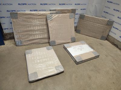 Plusieurs cartons contenant des matelas sont posés par terre devant un mur.