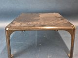 une table basse en laiton ancien avec un plateau en marbre sur fond bleu