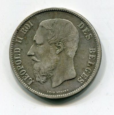 une vieille pièce de monnaie avec un visage d'homme sur une surface blanche