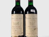 deux bouteilles de vin posées l'une à côté de l'autre sur une surface blanche