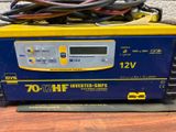 an image of a yellow and blue battery charger sitting on top of a wooden table