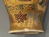 a gold vase with a picture of a woman on it