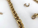 a lot of gold chains on a white surface