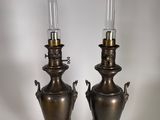 paire de lampes anciennes en forme d'urne en laiton, posées sur des socles en marbre