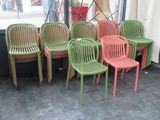 Plusieurs chaises vertes et rouges sont alignées devant une fenêtre