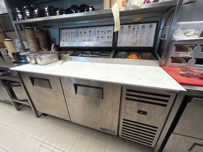 une cuisine équipée d'appareils électroménagers en inox et de plans de travail en inox