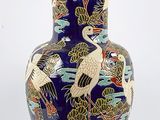 a blue vase with a design of birds and flowers on it