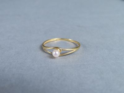 une bague en or surmontée d'une perle