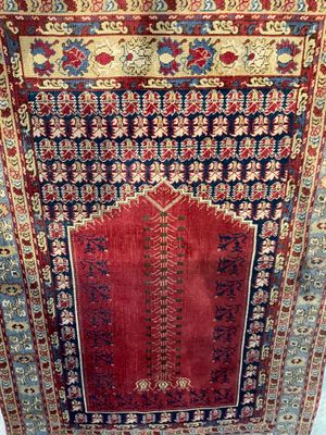 a red and blue rug hanging on a wall