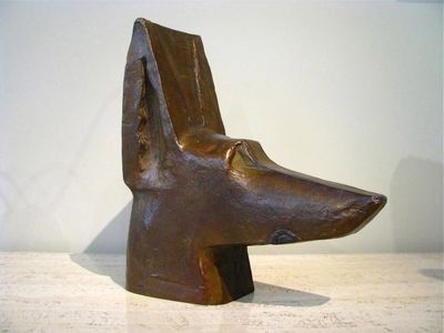 sculpture of a dog ' s head on a table with a white wall in the background
