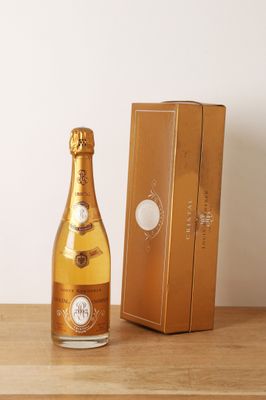 une bouteille de champagne posée sur une table à côté d'un coffret