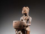 une image représentant une statue en bois d'un homme tenant un bol