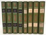 six green books are lined up in a row on a white surface