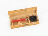 a small wooden box with a red handle and a spoon in it