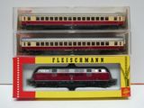 trois trains miniatures posés dans une boîte sur une surface blanche
