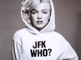 photo en noir et blanc d'une femme portant un sweat à capuche sur lequel est inscrit « jfk who ? »