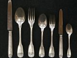 five forks, a knife, and a spoon on a table