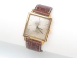 une montre posée sur une surface blanche