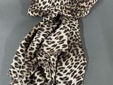 the leopard print scarf is laying on a gray surface
