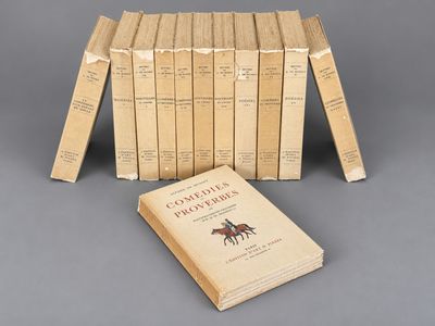 several books are stacked on top of each other on a gray surface