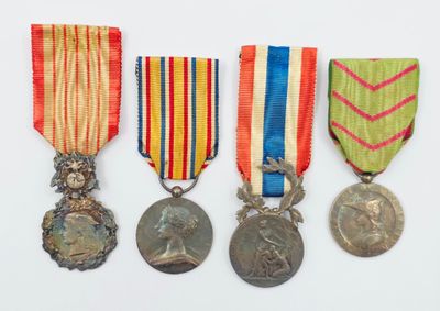 trois médailles et une médaille sur une surface blanche