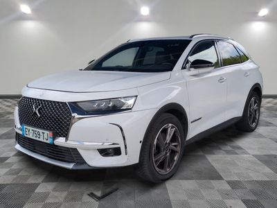une DSX blanche garée dans une pièce au sol à carreaux