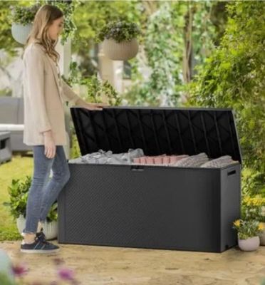 a woman standing next to an outdoor storage box