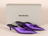 une paire de mules en satin violet avec une boîte blanche en arrière-plan