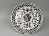 une assiette ancienne en noir et blanc sur laquelle figure un blason