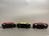 three toy cars are lined up in a row on a table